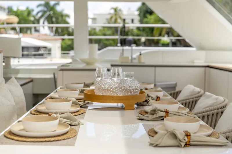 Fat Cat Yacht Photos Pics Elegant dining setup on 2024 Sunreef 80 Power yacht, featuring stylish tableware and modern decor.