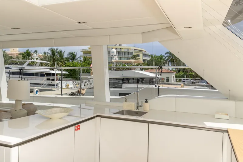 Fat Cat Yacht Photos Pics Luxurious interior of 2024 Sunreef 80 Power yacht with modern kitchen and marina view.