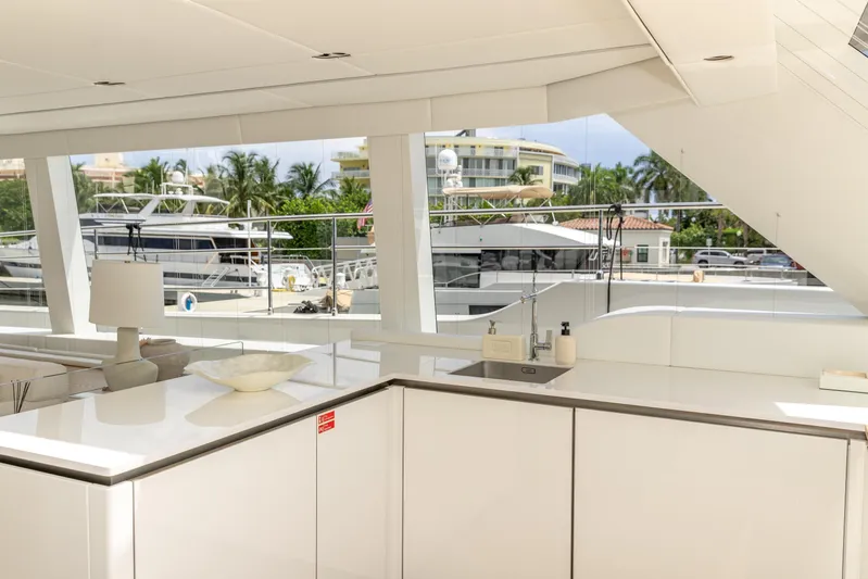 Fat Cat Yacht Photos Pics Luxurious interior of 2024 Sunreef 80 Power yacht with modern kitchen and scenic marina view.