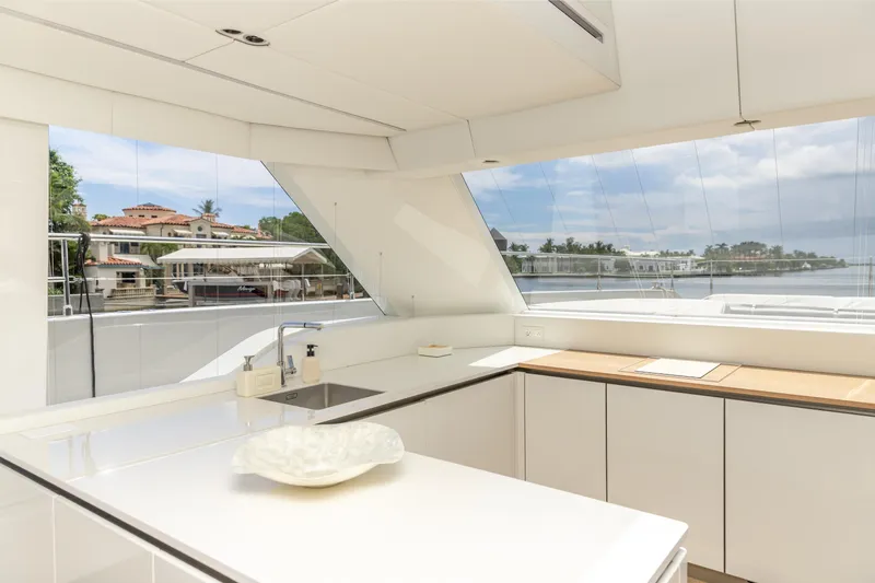 Fat Cat Yacht Photos Pics Luxurious interior of 2024 Sunreef 80 Power yacht with modern kitchen and scenic view.