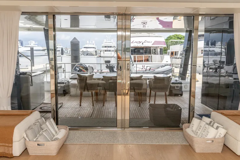 Fat Cat Yacht Photos Pics Luxurious Sunreef 80 Power yacht interior with glass doors, elegant seating, and marina view, 2024 model.