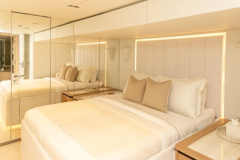 Fat Cat Yacht Photos Pics Luxurious bedroom interior on 2024 Sunreef 80 Power yacht, featuring elegant bedding and ambient lighting.