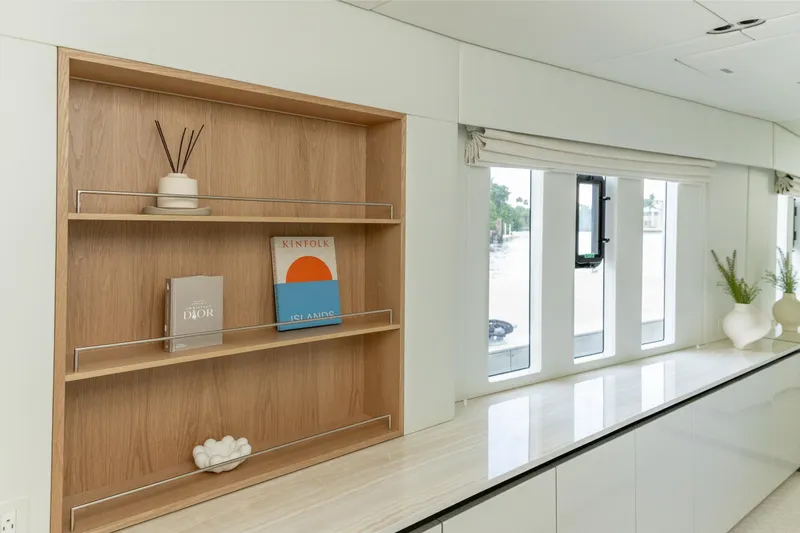 Fat Cat Yacht Photos Pics Modern interior of 2024 Sunreef 80 Power yacht with wooden shelves and decorative books.