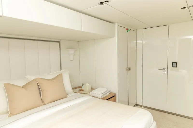Fat Cat Yacht Photos Pics Luxurious bedroom interior of 2024 Sunreef 80 Power yacht, featuring elegant white decor.