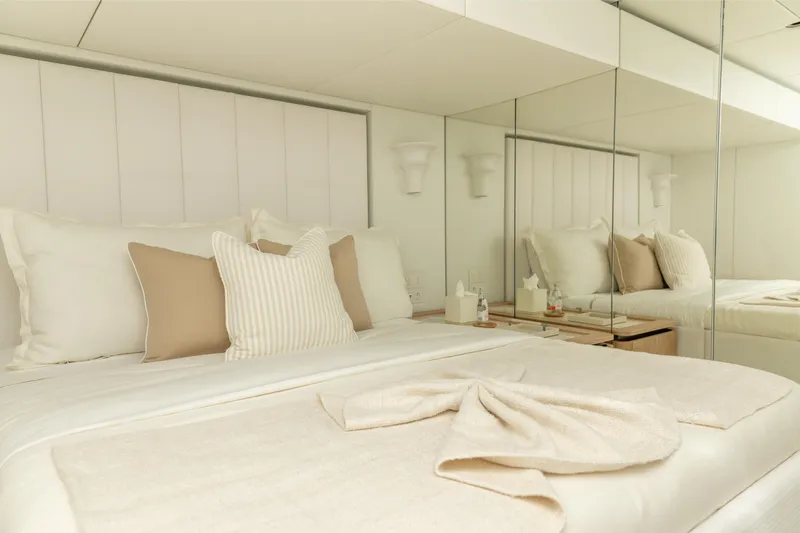 Fat Cat Yacht Photos Pics Luxurious bedroom interior on 2024 Sunreef 80 Power yacht with elegant bedding and mirrored wall.