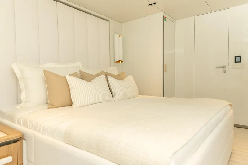 Fat Cat Yacht Photos Pics Luxurious bedroom interior of 2024 Sunreef 80 Power yacht with elegant bedding.
