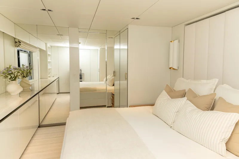 Fat Cat Yacht Photos Pics Luxurious bedroom interior of 2024 Sunreef 80 Power yacht, featuring elegant decor and plush bedding.