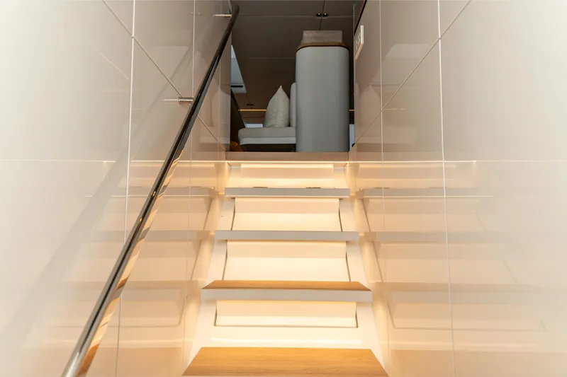 Fat Cat Yacht Photos Pics Staircase inside 2024 Sunreef 80 Power yacht, featuring sleek modern design and ambient lighting.