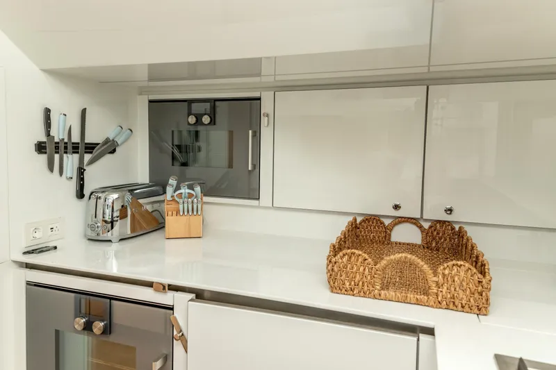 Fat Cat Yacht Photos Pics Modern kitchen in 2024 Sunreef 80 Power yacht with appliances and wicker basket.