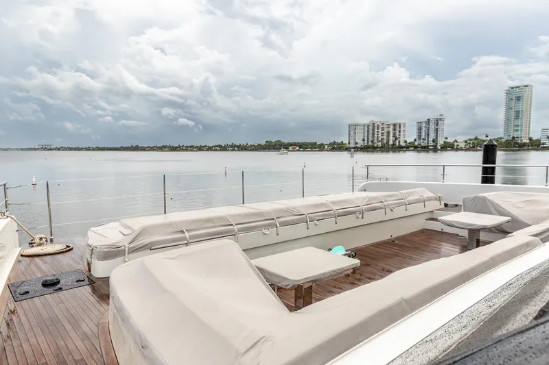 Fat Cat Yacht Photos Pics Luxurious Sunreef 80 Power yacht deck with seating, overlooking calm waters and city skyline, 2024 model.