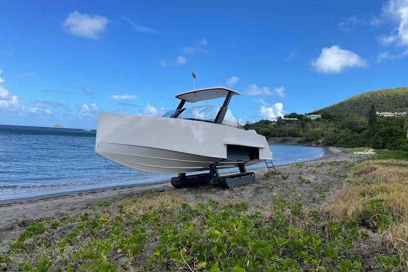  Yacht Photos Pics 2019 IGUANA Yachts Commuter on beach with retractable tracks, blue sky, and ocean backdrop.