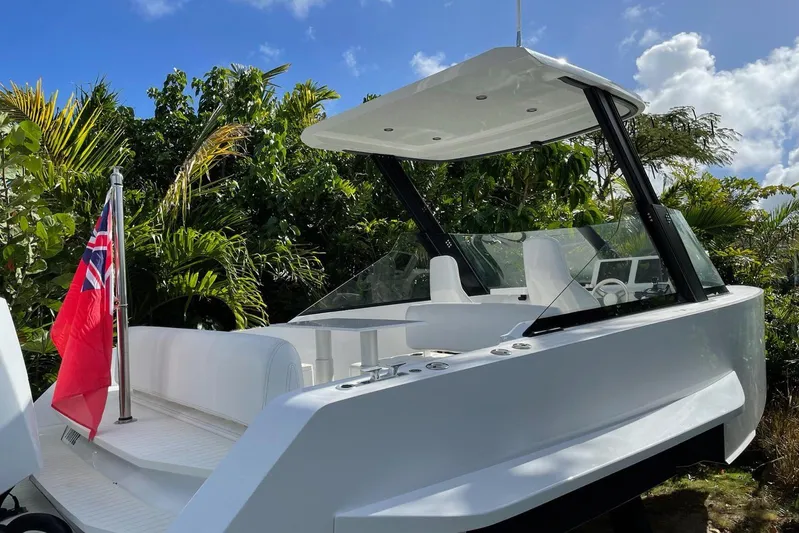  Yacht Photos Pics 2019 IGUANA Yachts Commuter with sleek design, docked near lush greenery.