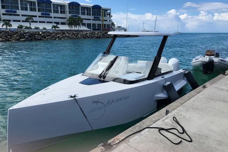  Yacht Photos Pics 2019 IGUANA Yachts Commuter docked by a waterfront building under a clear blue sky.