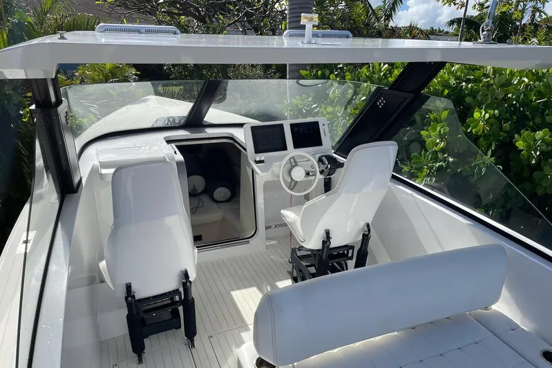  Yacht Photos Pics 2019 IGUANA Yachts Commuter interior with modern helm, dual screens, and white seating.