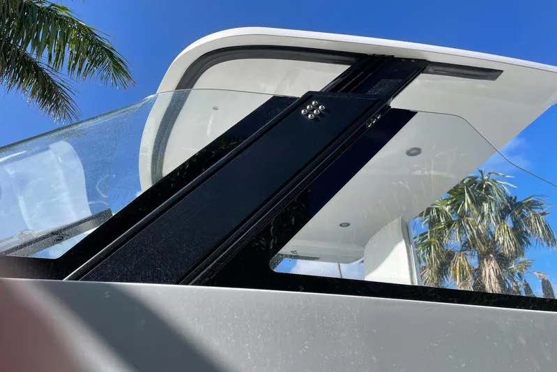  Yacht Photos Pics 2019 IGUANA Yachts Commuter with sleek design, glass panels, and tropical backdrop.