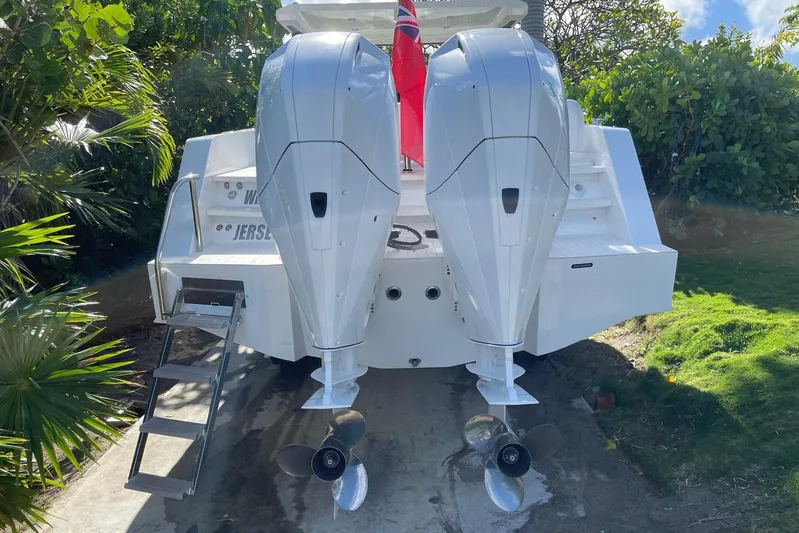  Yacht Photos Pics 2019 IGUANA Yachts Commuter with dual outboard motors, docked near lush greenery.