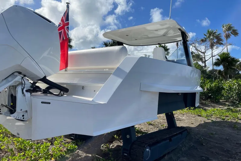  Yacht Photos Pics 2019 IGUANA Yachts Commuter with tracks, parked on sandy terrain under a blue sky.