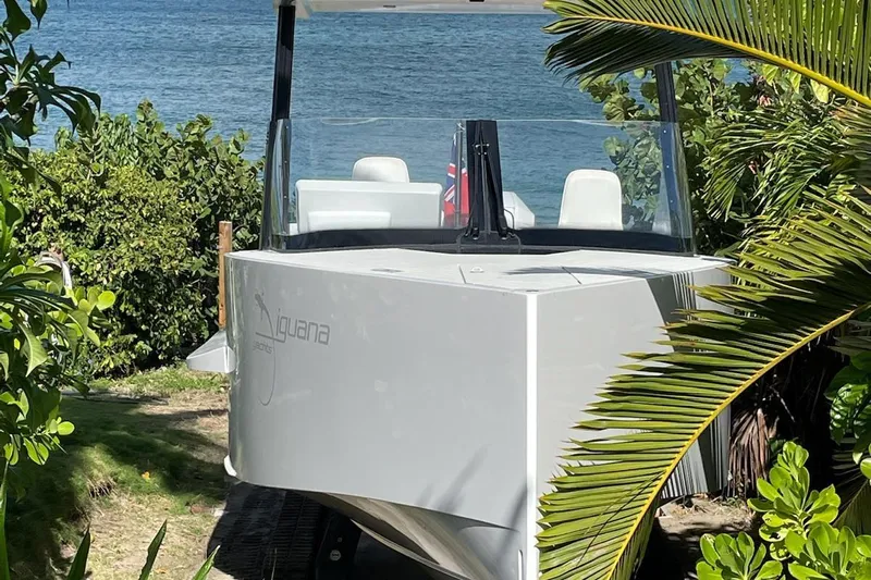  Yacht Photos Pics 2019 IGUANA Yachts Commuter on land, surrounded by lush greenery and ocean backdrop.