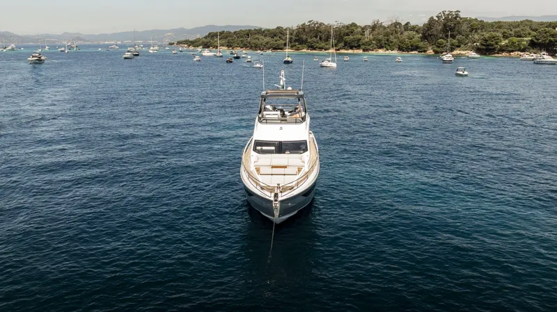  Yacht Photos Pics 2023 Azimut Fly 68 yacht anchored in a scenic bay with surrounding boats.