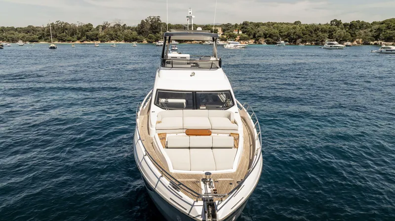  Yacht Photos Pics 2023 Azimut Fly 68 yacht on serene blue waters, surrounded by lush greenery.