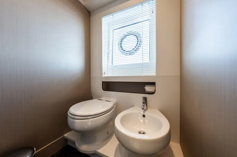  Yacht Photos Pics Luxurious bathroom on 2023 Azimut Fly 68 yacht with modern fixtures and porthole window.