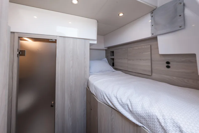  Yacht Photos Pics 2023 Azimut Fly 68 yacht cabin with modern wood finish and cozy bedding.