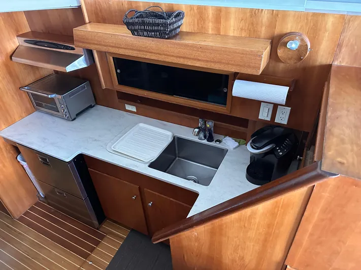 Kemo Sabe Yacht Photos Pics 1981 Bertram 45 Convertible yacht kitchen with sink, countertop, and appliances.
