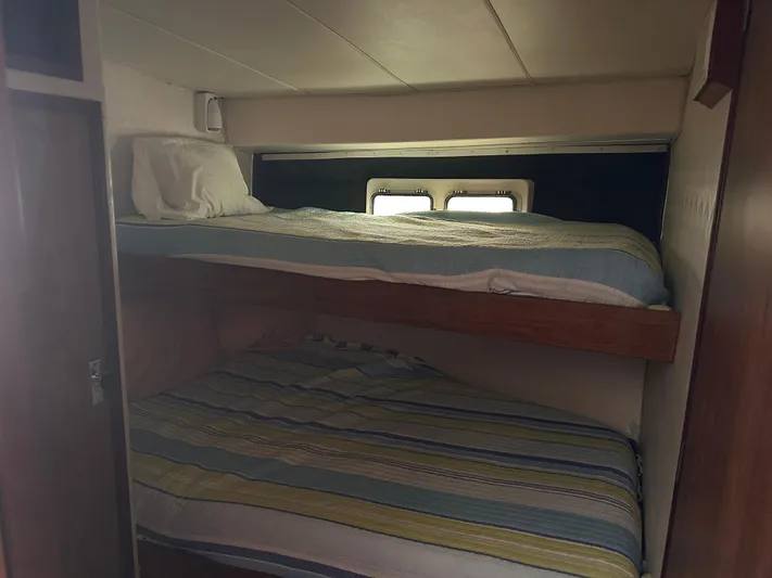 Kemo Sabe Yacht Photos Pics Bunk beds in 1981 Bertram 45 Convertible yacht cabin with striped bedding.