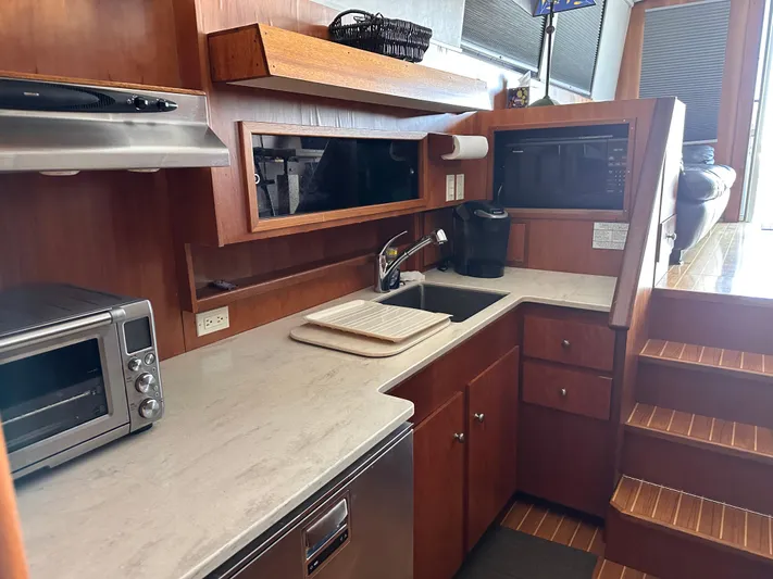 Kemo Sabe Yacht Photos Pics 1981 Bertram 45 Convertible yacht kitchen with modern appliances and wooden cabinetry.