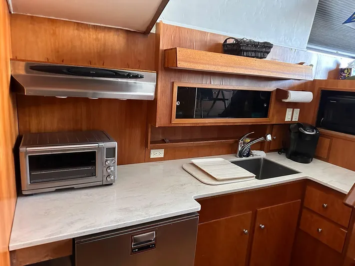 Kemo Sabe Yacht Photos Pics 1981 Bertram 45 Convertible yacht kitchen with modern appliances and wooden cabinetry.