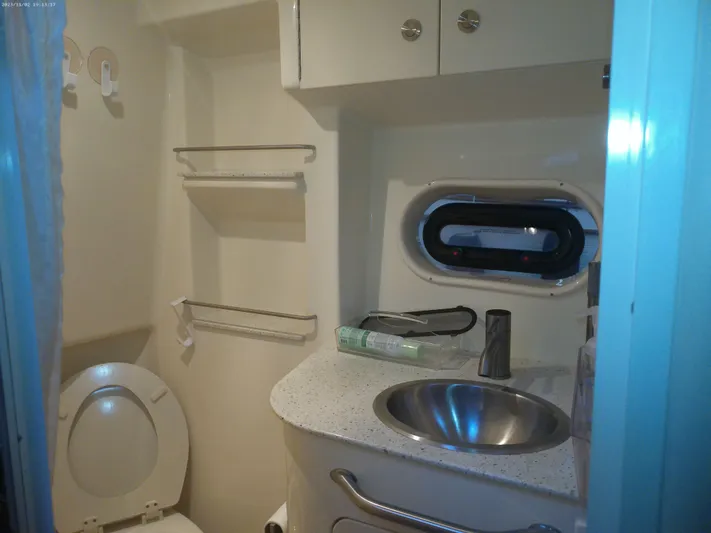 Stella Nautica Yacht Photos Pics 2015 Sea Ray 330 Sundancer bathroom with sink, toilet, and storage shelves.