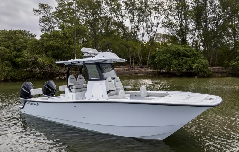  Yacht Photos Pics 2024 Freeman 28 boat on calm water near a forested shoreline.
