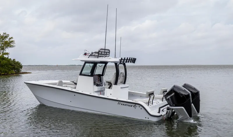  Yacht Photos Pics 2024 Freeman 28 boat with dual outboard motors on calm water.