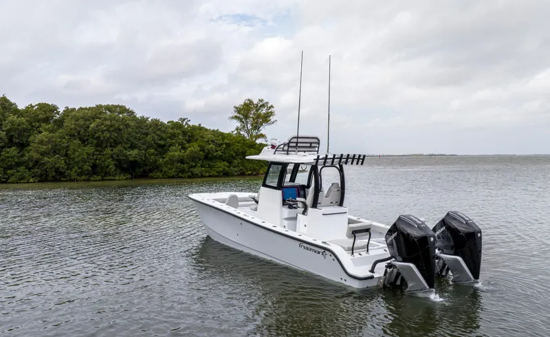  Yacht Photos Pics 2024 Freeman 28 boat with dual outboard motors on a calm lake.
