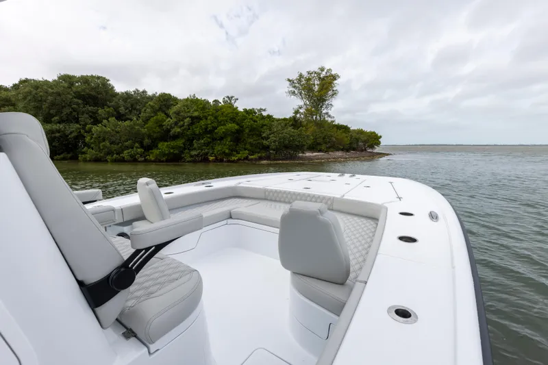  Yacht Photos Pics 2024 Freeman 28 boat with seating, near lush green shoreline.