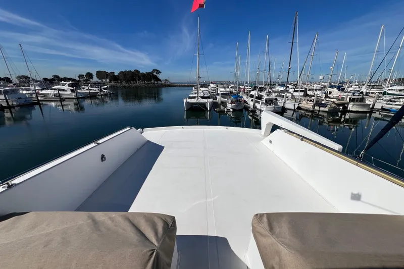 Kailani Yacht Photos Pics Viking 63 Motor Yacht 1991 at marina, clear sky, calm waters, sailboats docked nearby.