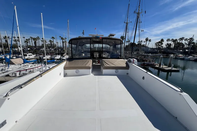 Kailani Yacht Photos Pics 1991 Viking 63 Motor Yacht deck view in marina, clear sky, palm trees in background.