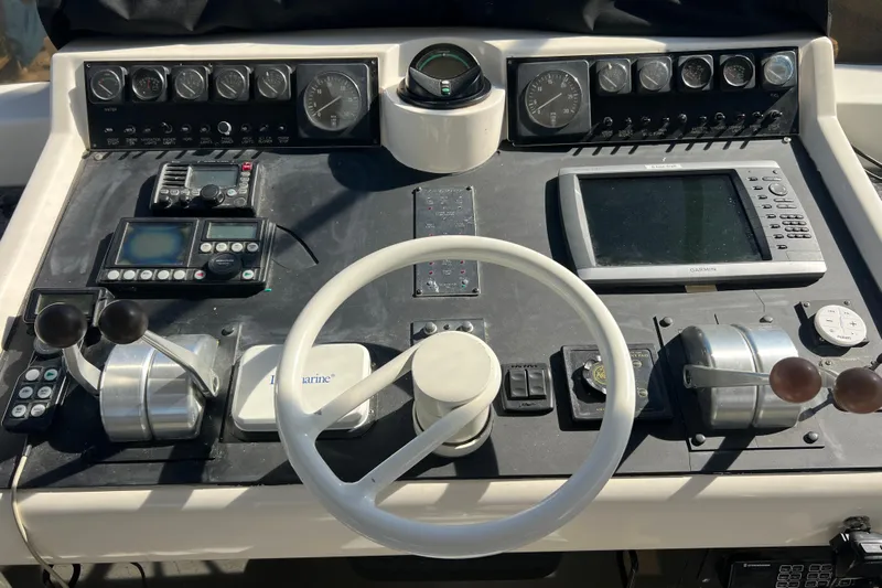 Kailani Yacht Photos Pics Control panel of a 1991 Viking 63 Motor Yacht with navigation instruments and steering wheel.