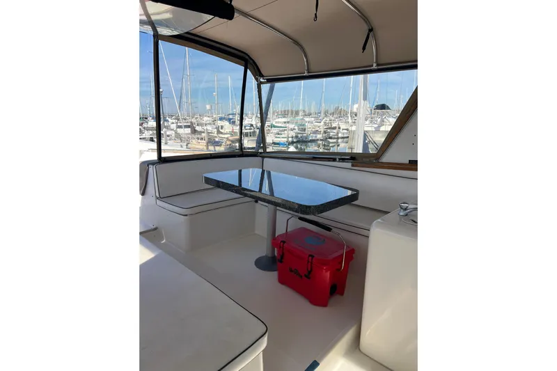 Kailani Yacht Photos Pics Flybridge enclosure and seating, table, and marina view.