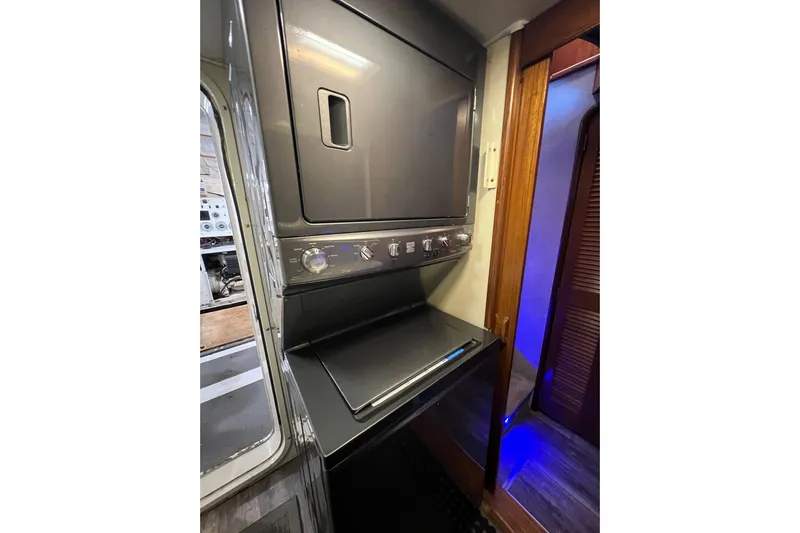 Kailani Yacht Photos Pics Laundry area outside of engineroom door access with stacked washer and dryer.