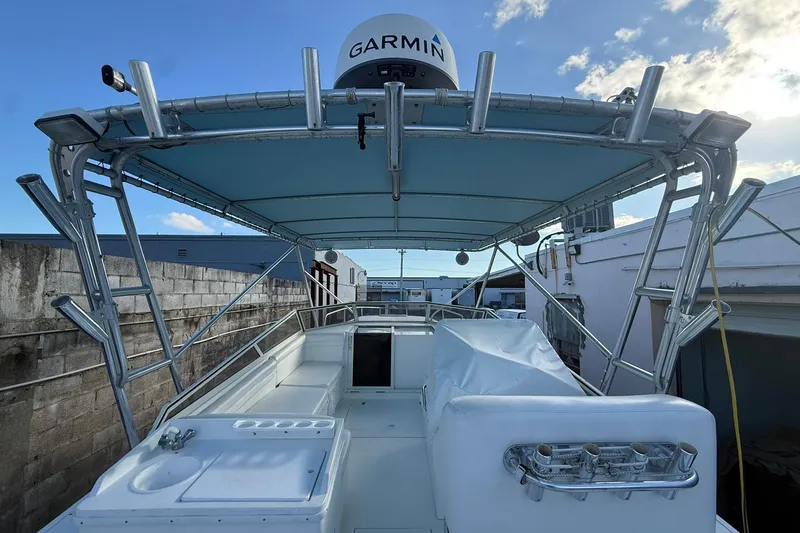 Reel Dreamz Yacht Photos Pics 1998 Contender 35 Express boat with Garmin radar, docked under a blue sky.