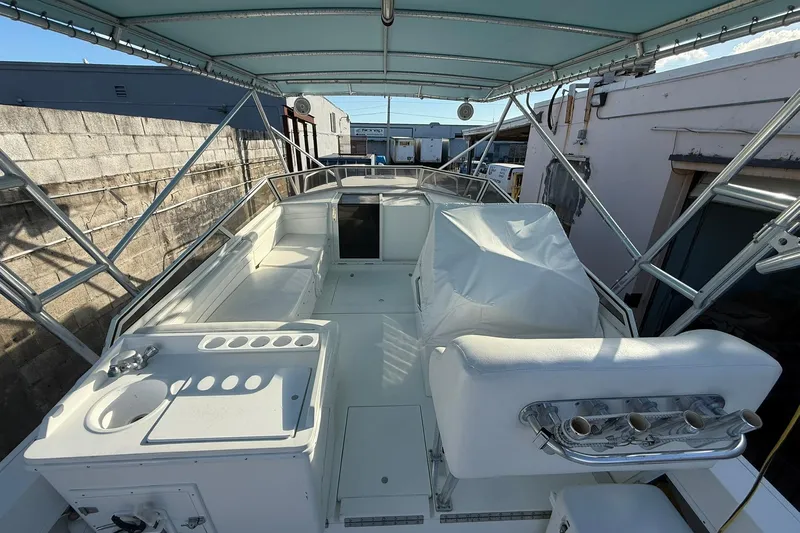 Reel Dreamz Yacht Photos Pics 1998 Contender 35 Express boat interior with seating, sink, and rod holders under a canopy.