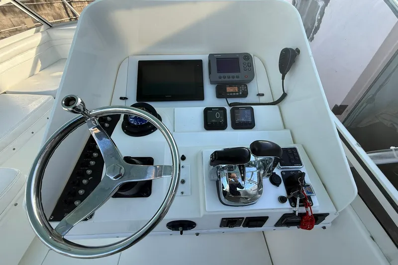 Reel Dreamz Yacht Photos Pics 1998 Contender 35 Express helm with steering wheel, controls, and navigation equipment.