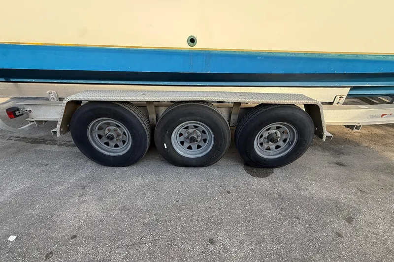 Reel Dreamz Yacht Photos Pics Triple-axle trailer with Contender 35 Express boat, 1998 model, on pavement.