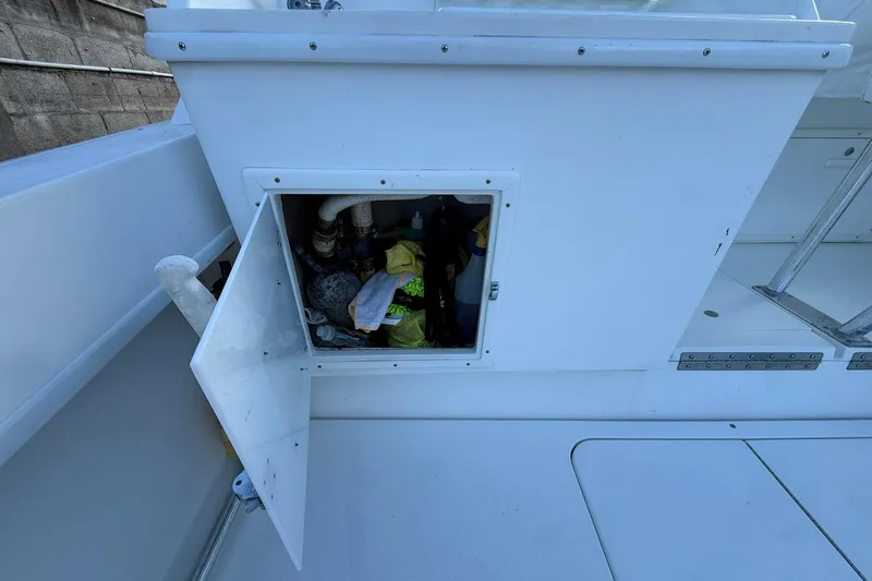 Reel Dreamz Yacht Photos Pics Open storage compartment on a 1998 Contender 35 Express boat, revealing various items inside.
