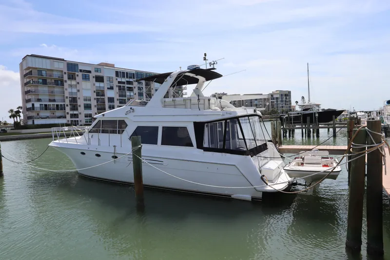 Fitz Perfectly Yacht Photos Pics Navigator 4800 CLASSIC yacht docked in marina, 2001 model, with modern buildings in background.