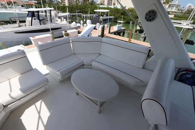 Fitz Perfectly Yacht Photos Pics Spacious seating area on 2001 Navigator 4800 CLASSIC yacht, featuring white cushioned seats and table.