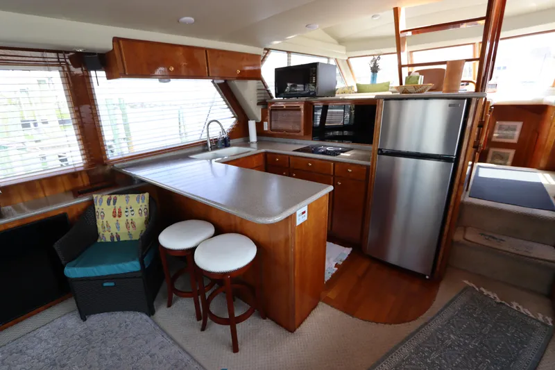 Fitz Perfectly Yacht Photos Pics 2001 Navigator 4800 CLASSIC yacht interior with kitchen, bar stools, and modern appliances.