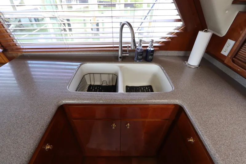 Fitz Perfectly Yacht Photos Pics Kitchen sink area in 2001 Navigator 4800 CLASSIC yacht with wooden cabinetry and countertop.