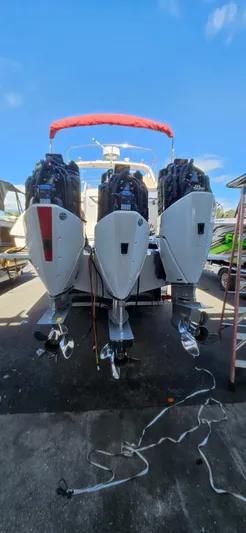  Yacht Photos Pics 2006 Fountain 38 Express Cruiser with triple outboard engines, docked under a clear blue sky.